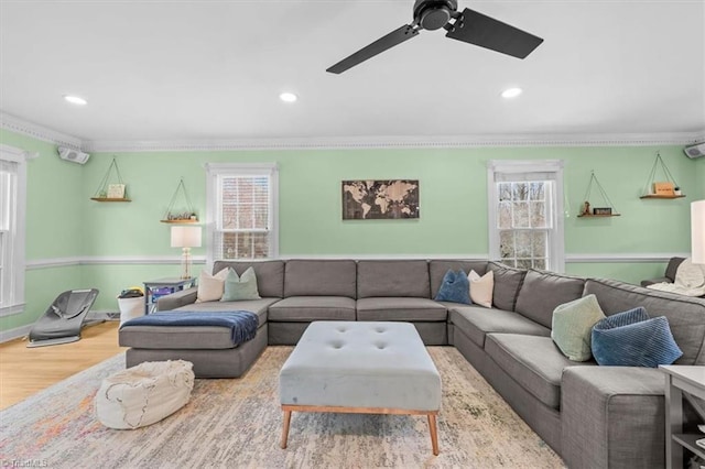 living area featuring ceiling fan, wood finished floors, ornamental molding, and recessed lighting