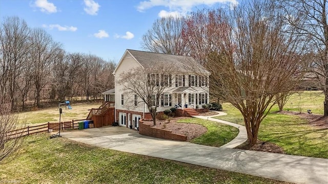 view of front of home with a front lawn, french doors, fence, and driveway