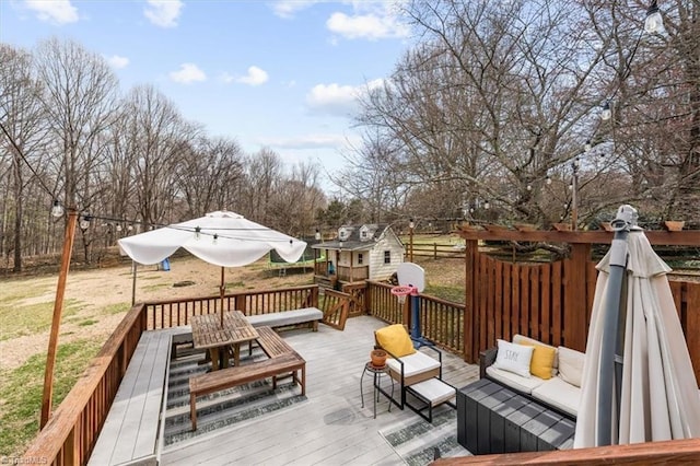 deck with an outdoor hangout area, an outbuilding, outdoor dining space, and a shed