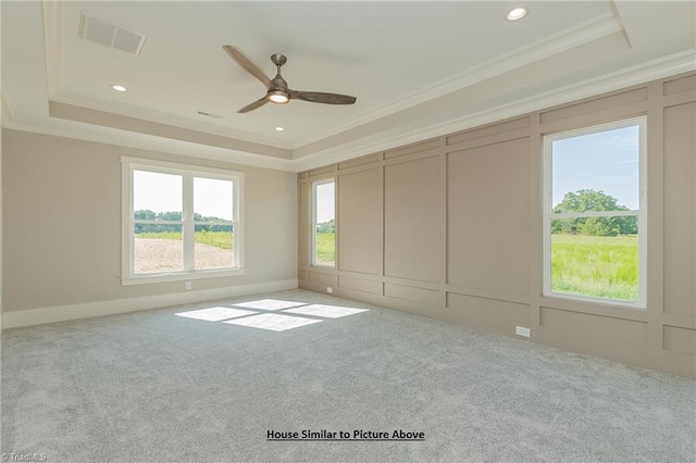 carpeted empty room with a tray ceiling, ceiling fan, and crown molding