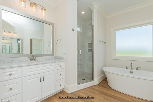 bathroom featuring hardwood / wood-style flooring, independent shower and bath, vanity, crown molding, and decorative columns