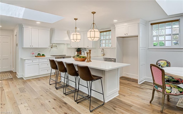 kitchen featuring white cabinetry, a skylight, and a kitchen island