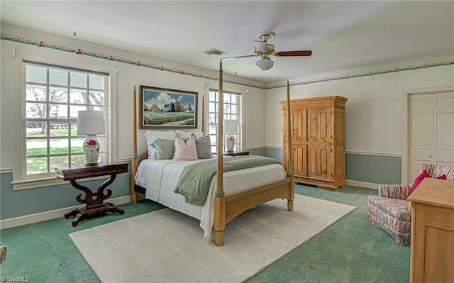 carpeted bedroom with multiple windows, ornamental molding, a closet, and ceiling fan