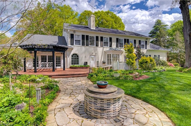 back of property with a patio, a lawn, and a pergola