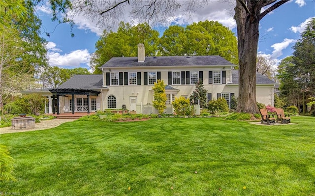 back of house with a yard, a patio area, and a fire pit