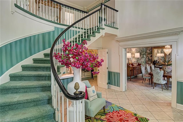 stairway with a towering ceiling and tile patterned flooring