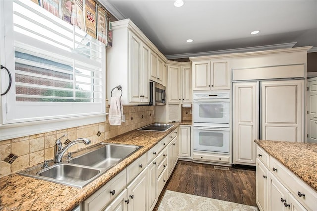 kitchen featuring ornamental molding, a sink, double oven, black electric cooktop, and dark wood-style flooring