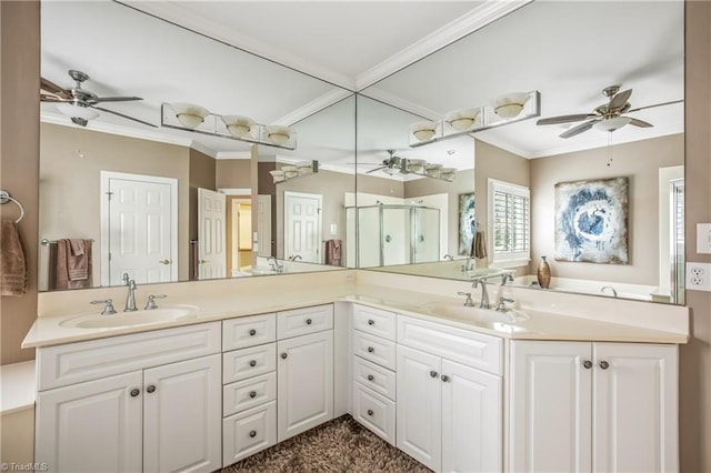 bathroom featuring a sink, a shower stall, crown molding, and double vanity