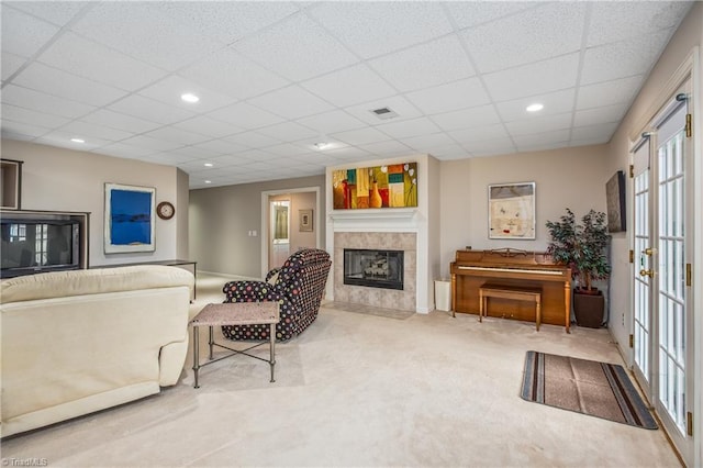 carpeted living room featuring recessed lighting, a fireplace, visible vents, and a drop ceiling