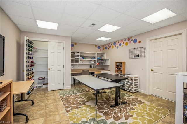 home office featuring a drop ceiling, baseboards, and visible vents