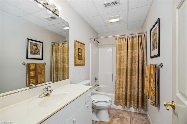 full bath with toilet, a paneled ceiling, and visible vents