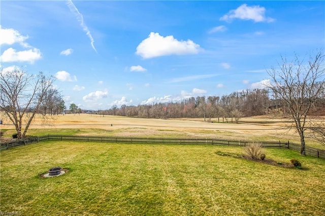 view of yard featuring a rural view, fence private yard, and an outdoor fire pit