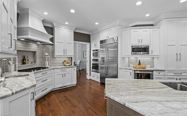 1905 Regents Park Ln, Greensboro, NC 27455 - kitchen featuring built in appliances, premium range hood, a sink, recessed lighting, and wine cooler