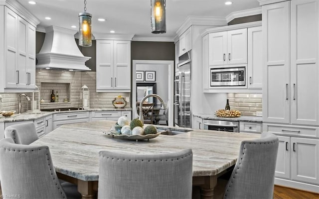 1905 Regents Park Ln, Greensboro, NC 27455 - kitchen with appliances with stainless steel finishes, custom exhaust hood, recessed lighting, white cabinetry, and a sink