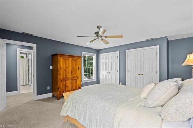 1905 Regents Park Ln, Greensboro, NC 27455 - bedroom featuring two closets, light carpet, a ceiling fan, and baseboards