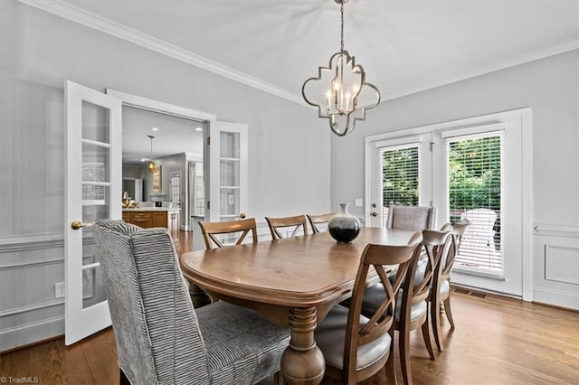 1905 Regents Park Ln, Greensboro, NC 27455 - dining space featuring ornamental molding, wood finished floors, and a chandelier