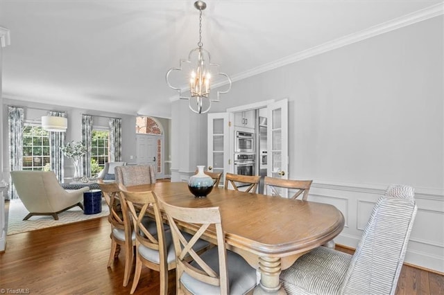 1905 Regents Park Ln, Greensboro, NC 27455 - dining area with a chandelier, crown molding, dark wood-style floors, and a wainscoted wall