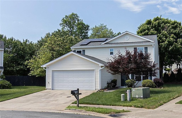 traditional home featuring driveway, a garage, a front lawn, and roof mounted solar panels
