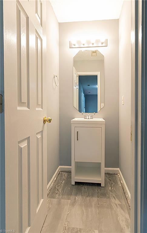 bathroom with baseboards, vanity, and marble finish floors