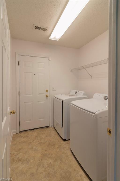 clothes washing area with washing machine and dryer