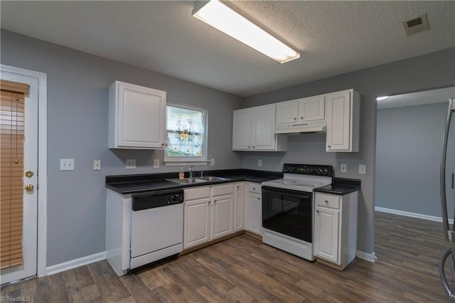 kitchen with electric range oven, white dishwasher, a sink, white cabinetry, and dark countertops