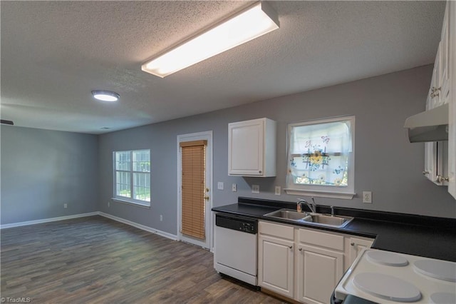 kitchen featuring dishwasher, a sink, a textured ceiling, dark countertops, and range with electric cooktop
