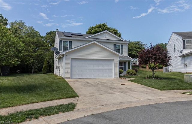 traditional-style home with a front yard, solar panels, concrete driveway, and a garage