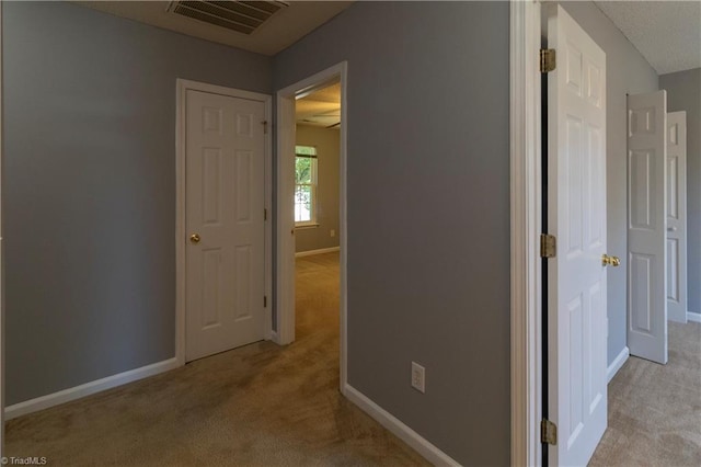 hallway with carpet floors and baseboards