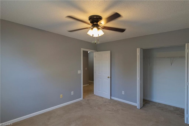 unfurnished bedroom with a closet, light carpet, baseboards, a ceiling fan, and a textured ceiling