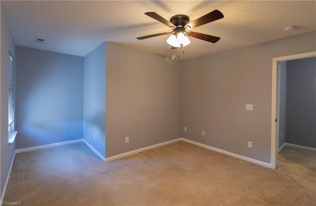 spare room with light carpet, a ceiling fan, baseboards, a textured ceiling, and a smoke detector