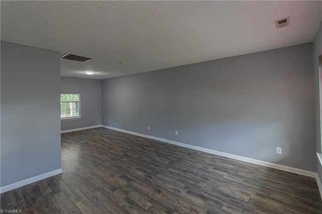 spare room with dark wood finished floors, baseboards, and a textured ceiling