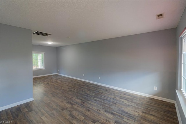 spare room with dark wood-type flooring and baseboards