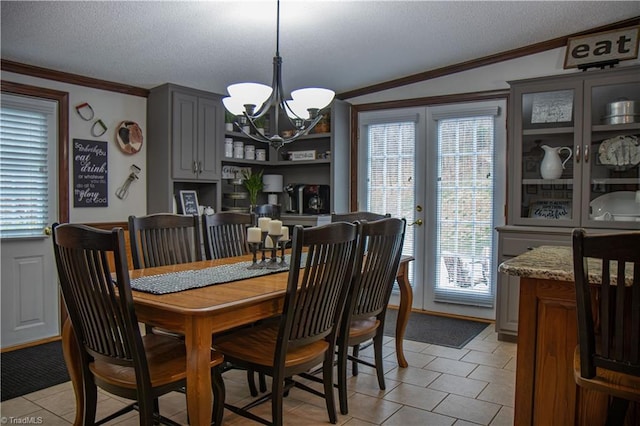 dining space featuring crown molding, light tile patterned flooring, a chandelier, and a textured ceiling