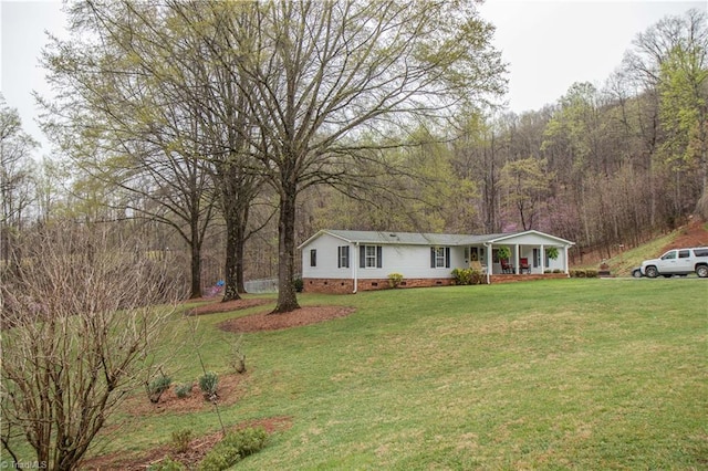 view of front of property featuring a front yard, a porch, a view of trees, and crawl space