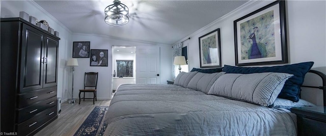 bedroom with crown molding, baseboards, light wood finished floors, and vaulted ceiling
