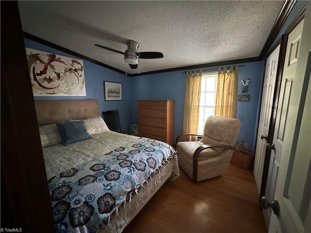 bedroom featuring ornamental molding, a ceiling fan, wood finished floors, and a textured ceiling