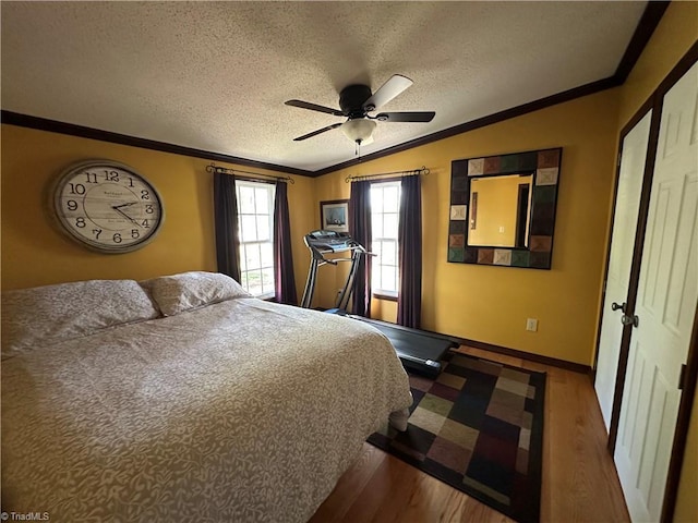 bedroom featuring crown molding, ceiling fan, a textured ceiling, wood finished floors, and lofted ceiling