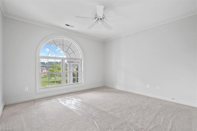 spare room featuring ornamental molding, baseboards, visible vents, and carpet flooring