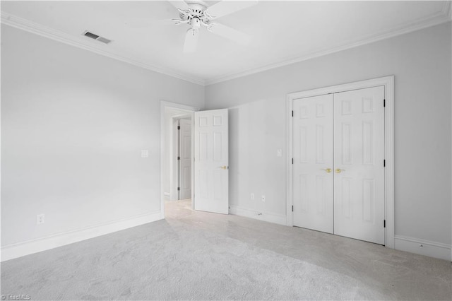 unfurnished bedroom with baseboards, carpet flooring, visible vents, and crown molding