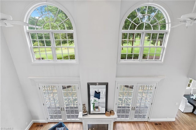 interior space featuring visible vents, french doors, wood finished floors, and a ceiling fan