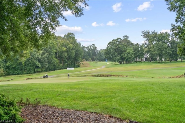 surrounding community featuring a lawn and golf course view