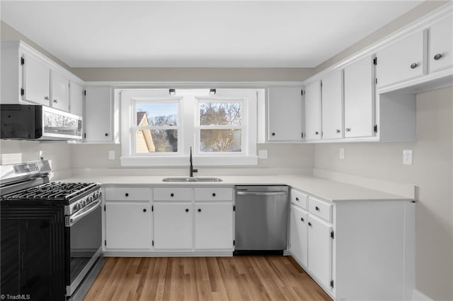 kitchen with sink, stainless steel appliances, and white cabinets