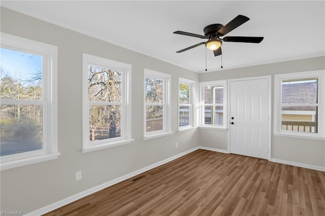 unfurnished sunroom with ceiling fan