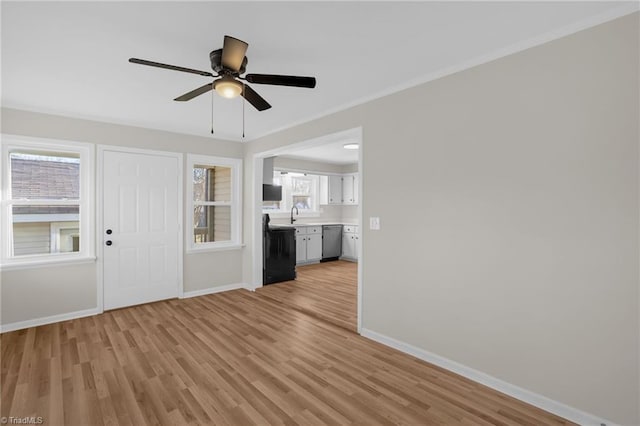 unfurnished living room featuring ceiling fan, sink, crown molding, and light hardwood / wood-style floors