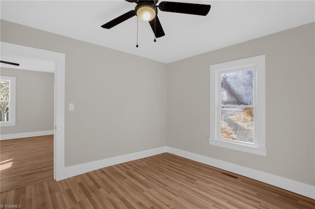 empty room with ceiling fan and light hardwood / wood-style floors