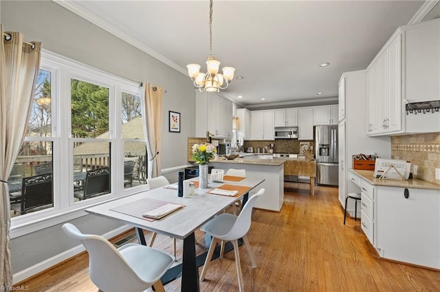 dining area featuring light wood finished floors, an inviting chandelier, baseboards, ornamental molding, and recessed lighting