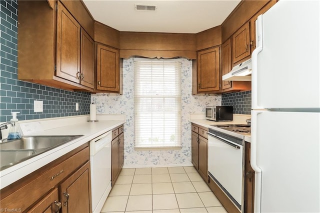 3905 Valley Ct Unit F, Winston-Salem, NC 27106 - kitchen featuring white appliances, wallpapered walls, under cabinet range hood, light countertops, and brown cabinetry