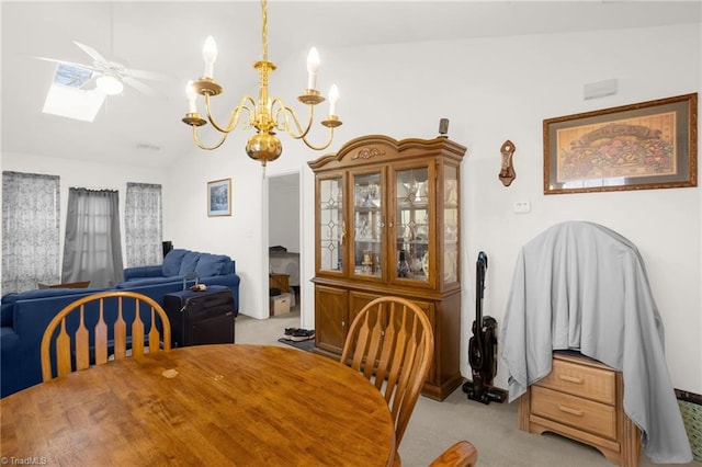 dining room featuring light colored carpet, vaulted ceiling with skylight, and a notable chandelier