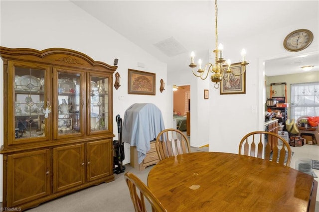 dining area with light colored carpet, lofted ceiling, and a chandelier