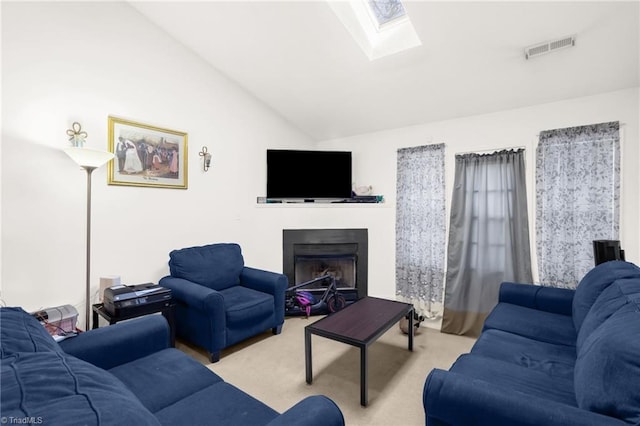 carpeted living room with lofted ceiling with skylight